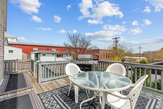 wooden terrace featuring outdoor dining area and grilling area