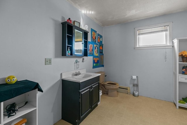 bathroom with baseboard heating, a textured ceiling, toilet, vanity, and tile patterned floors
