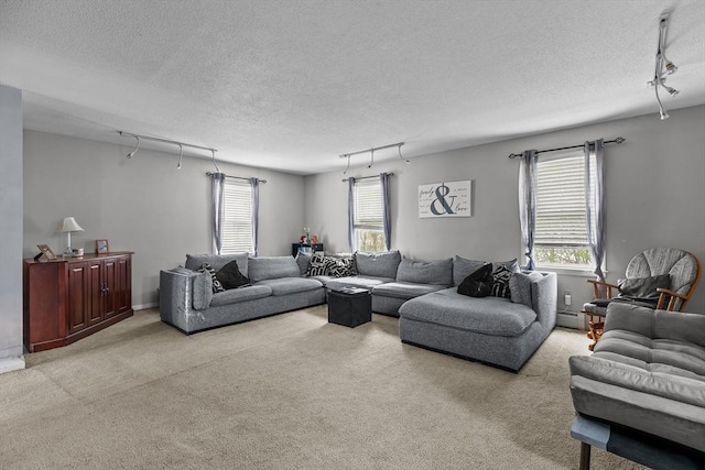 carpeted living room featuring track lighting, a textured ceiling, a baseboard radiator, and healthy amount of natural light
