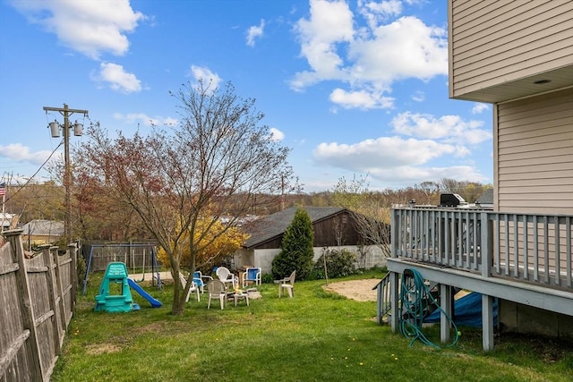view of yard featuring a wooden deck and a playground