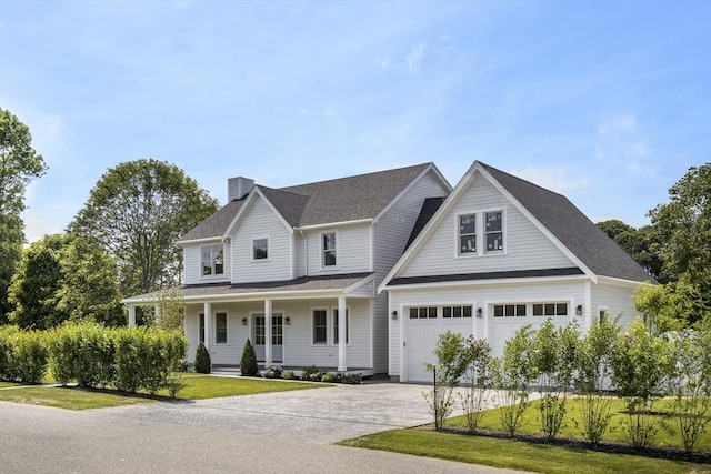 30 Franklin Ave, Oak Bluffs, MA 02557 - view of front of property with a chimney, driveway, covered porch, a front lawn, and a garage