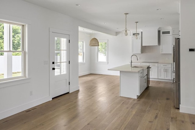 30 Franklin Ave, Oak Bluffs, MA 02557 - kitchen with healthy amount of natural light, light wood finished floors, light countertops, white cabinets, and recessed lighting