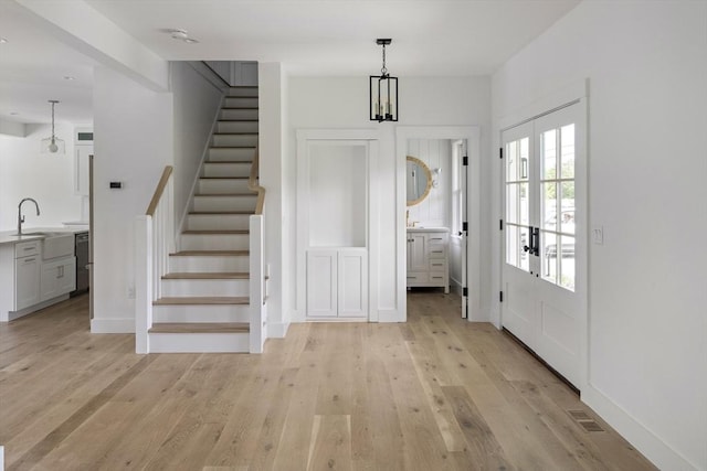 30 Franklin Ave, Oak Bluffs, MA 02557 - foyer entrance with light wood-type flooring, stairs, and baseboards