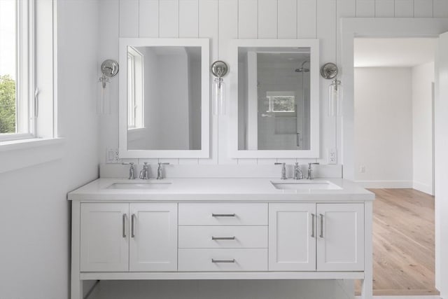 30 Franklin Ave, Oak Bluffs, MA 02557 - full bathroom with tiled shower, double vanity, wood finished floors, and baseboards