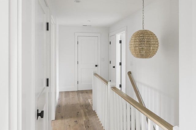 30 Franklin Ave, Oak Bluffs, MA 02557 - hallway with an upstairs landing, light wood finished floors, and a chandelier