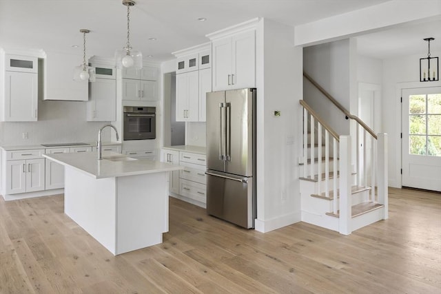 30 Franklin Ave, Oak Bluffs, MA 02557 - kitchen with high quality fridge, wall oven, a sink, light countertops, and light wood-type flooring
