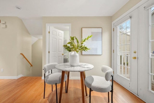 dining area with light wood-type flooring and baseboards