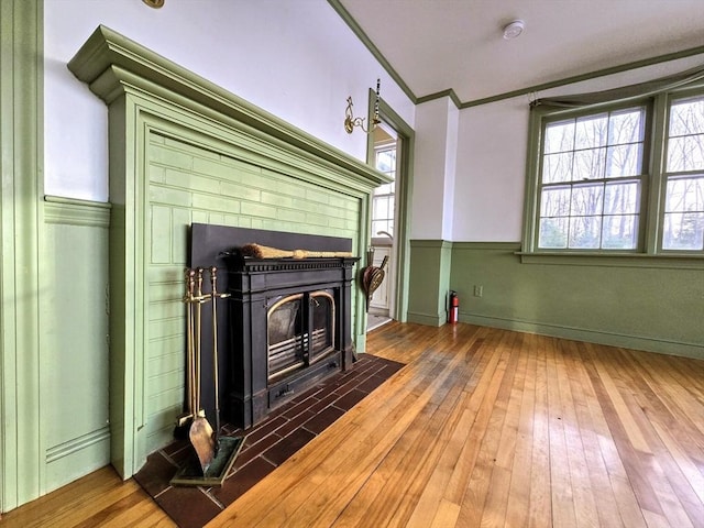 unfurnished living room featuring dark hardwood / wood-style flooring, a wood stove, plenty of natural light, and crown molding