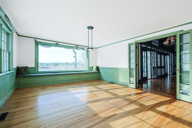 unfurnished dining area featuring hardwood / wood-style flooring and an inviting chandelier