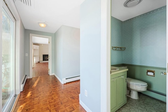 bathroom with vanity, a baseboard radiator, and toilet