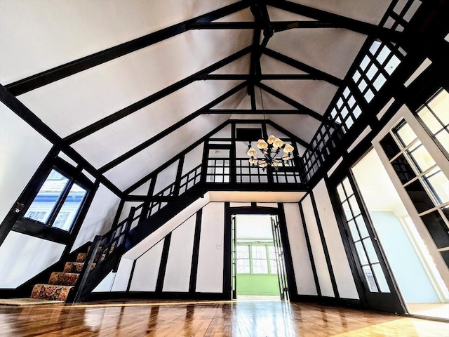 unfurnished living room featuring a high ceiling and an inviting chandelier