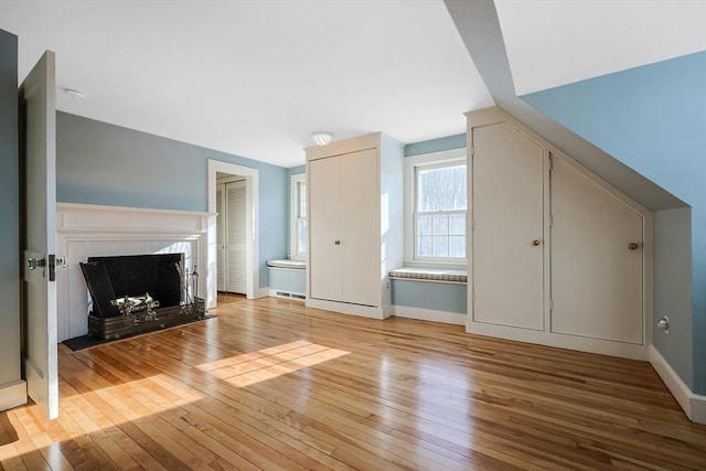 additional living space featuring vaulted ceiling and light hardwood / wood-style flooring