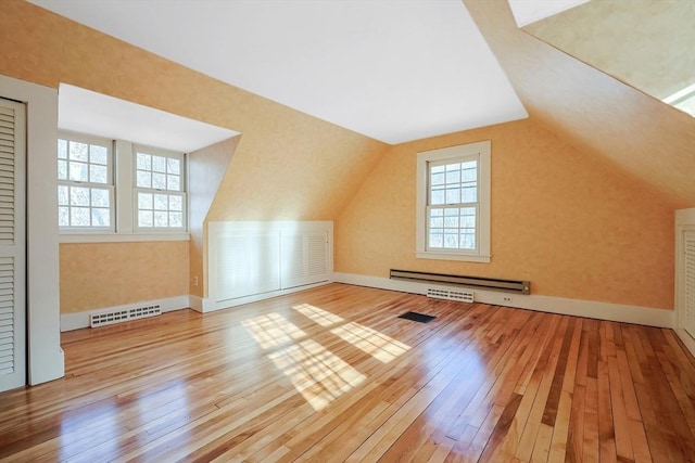 bonus room featuring lofted ceiling, light wood-type flooring, and baseboard heating