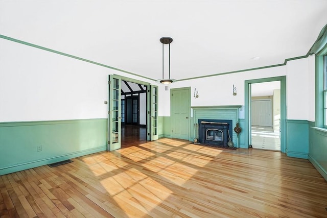 unfurnished living room featuring crown molding and light wood-type flooring