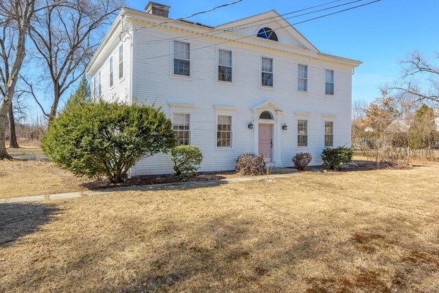 view of front of property featuring a chimney and a front lawn