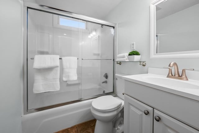 full bathroom with enclosed tub / shower combo, vanity, and toilet