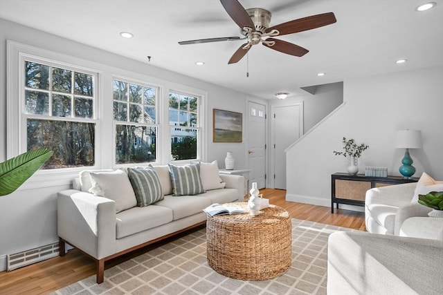 living room featuring ceiling fan, a baseboard radiator, and wood-type flooring