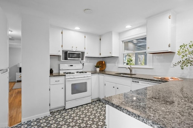 kitchen with sink, white cabinetry, white appliances, dark stone counters, and backsplash