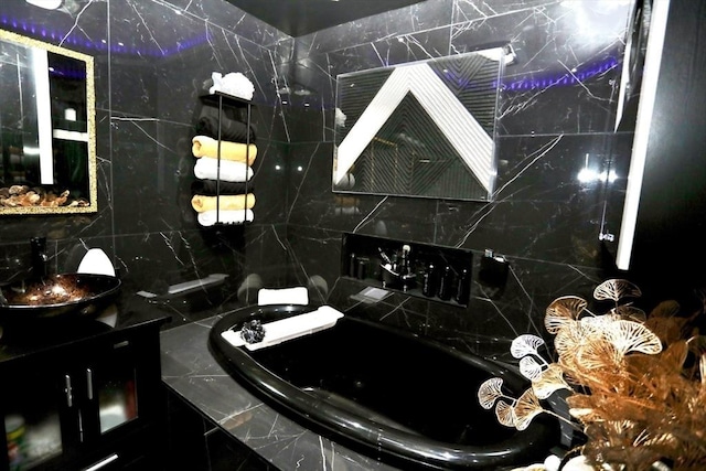 bathroom featuring a relaxing tiled tub and vanity