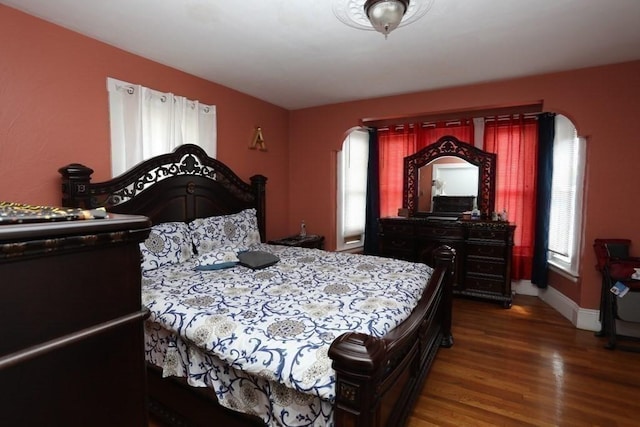 bedroom with dark hardwood / wood-style flooring