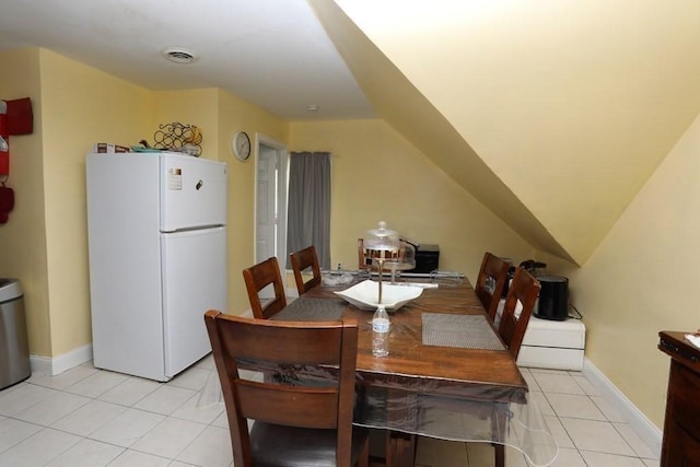 tiled dining area featuring lofted ceiling