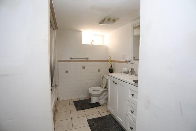 bathroom with tile patterned floors, toilet, vanity, and tile walls