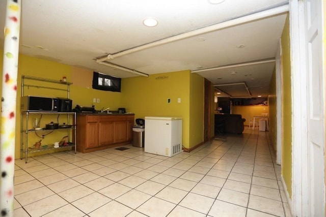 kitchen with light tile patterned flooring, sink, and refrigerator