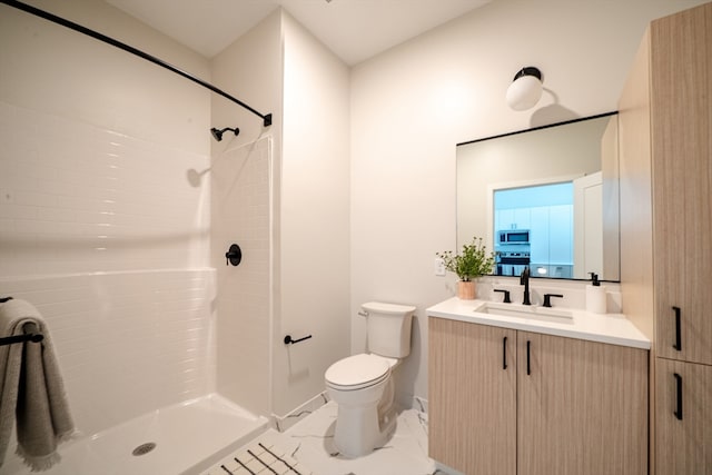 bathroom with toilet, vanity, and a shower