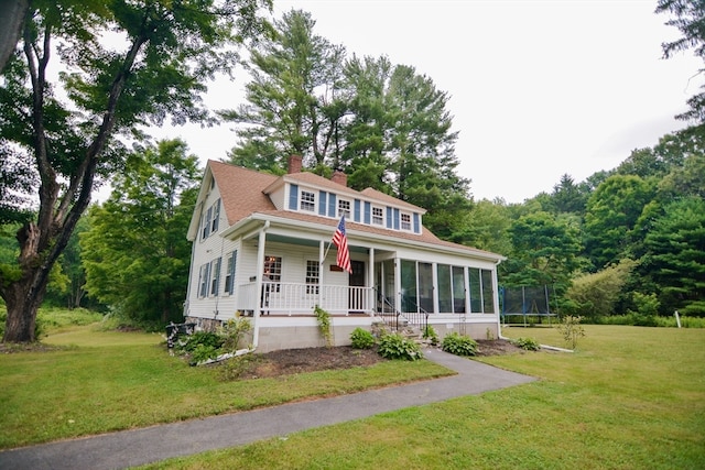 view of front of property featuring a trampoline, a front lawn, and covered porch