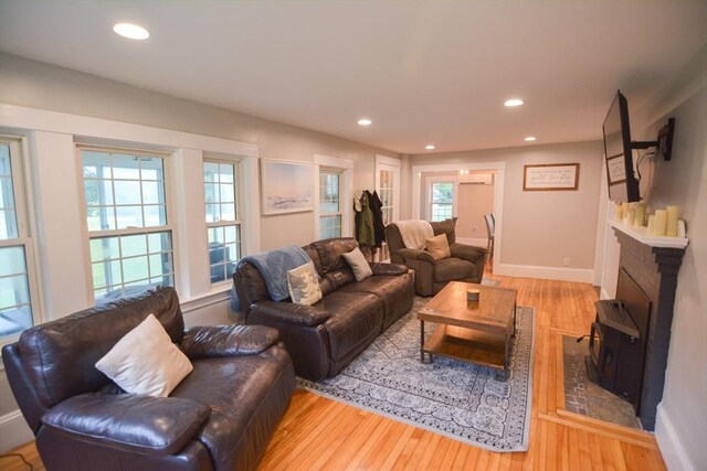 living room featuring a wall mounted AC and light hardwood / wood-style floors