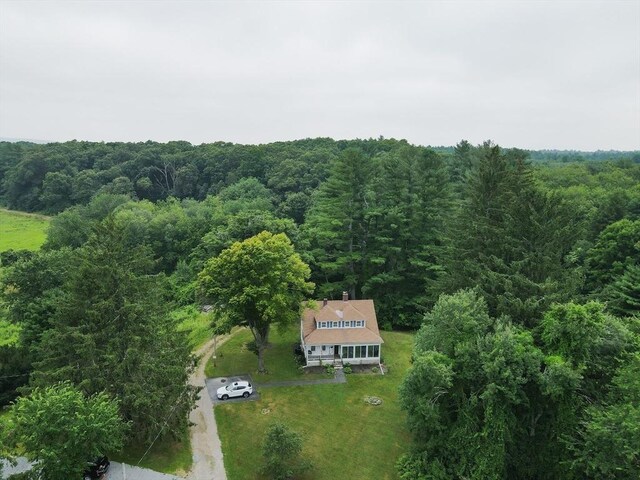 view of front of home with a trampoline, a sunroom, and a front lawn