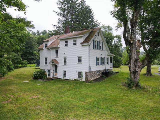 rear view of house featuring a yard