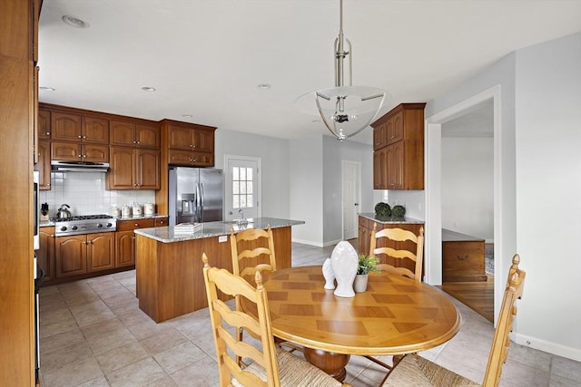 267 Barnes Rd, Oak Bluffs, MA 02557 - kitchen featuring stainless steel appliances, a center island, baseboards, exhaust hood, and decorative backsplash