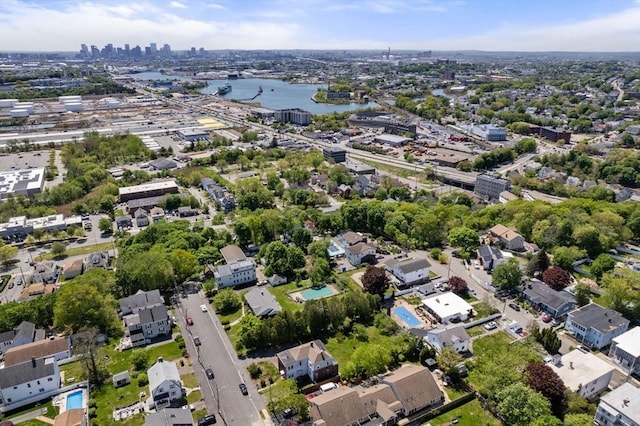 aerial view of property's location featuring a nearby body of water, a skyline view, and nearby suburban area