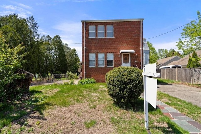 townhome / multi-family property with brick siding and fence