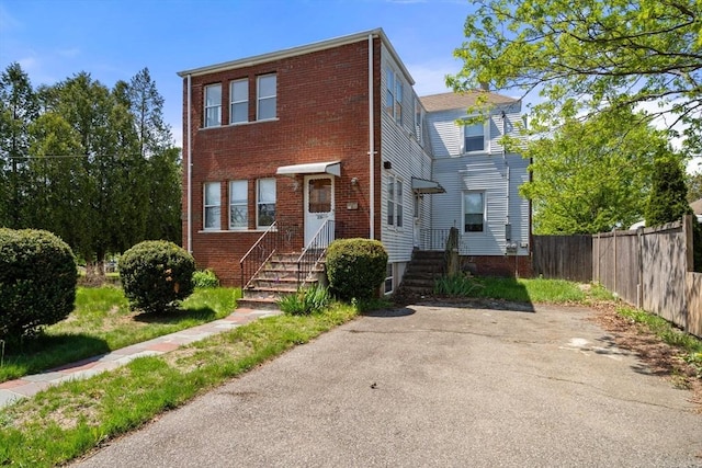 townhome / multi-family property with fence and brick siding