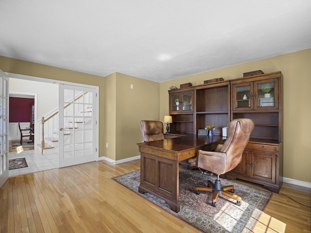 home office with baseboards and light wood-style flooring