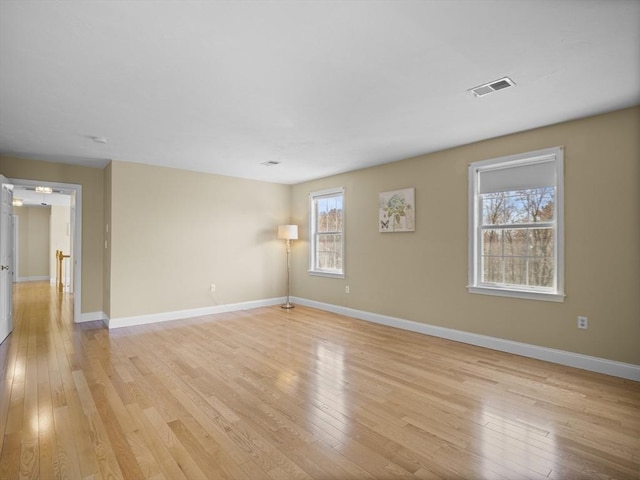 spare room with visible vents, baseboards, and light wood-style floors