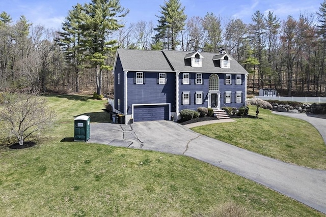colonial inspired home featuring a front lawn, aphalt driveway, and a garage