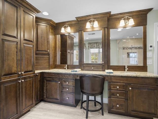 bathroom with double vanity, visible vents, and a sink