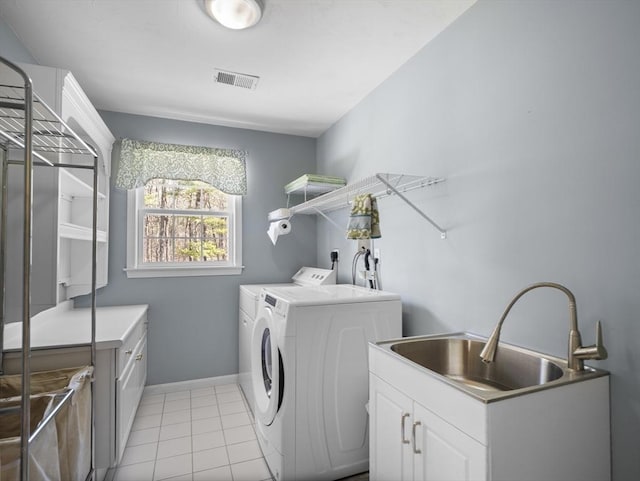 laundry area featuring a sink, light tile patterned flooring, cabinet space, visible vents, and independent washer and dryer