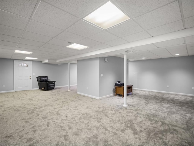 finished below grade area with baseboards, carpet flooring, and a drop ceiling