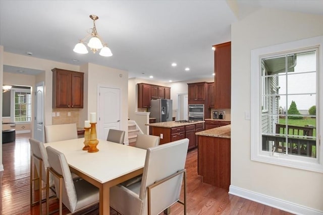 dining space featuring a chandelier, recessed lighting, baseboards, and wood finished floors