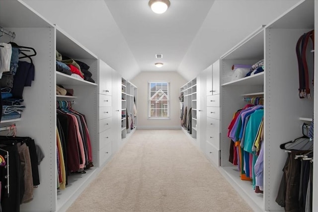 walk in closet featuring light colored carpet and vaulted ceiling