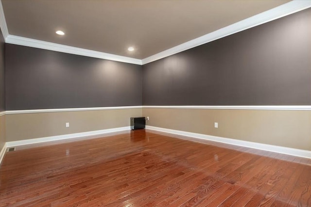 spare room featuring crown molding, visible vents, wood finished floors, and baseboards