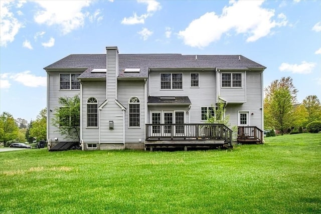 rear view of house with a yard, a deck, and a chimney