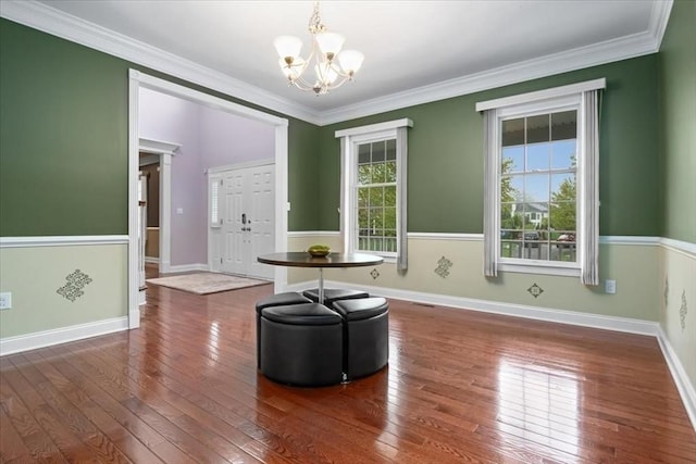 interior space with ornamental molding, hardwood / wood-style floors, and a notable chandelier