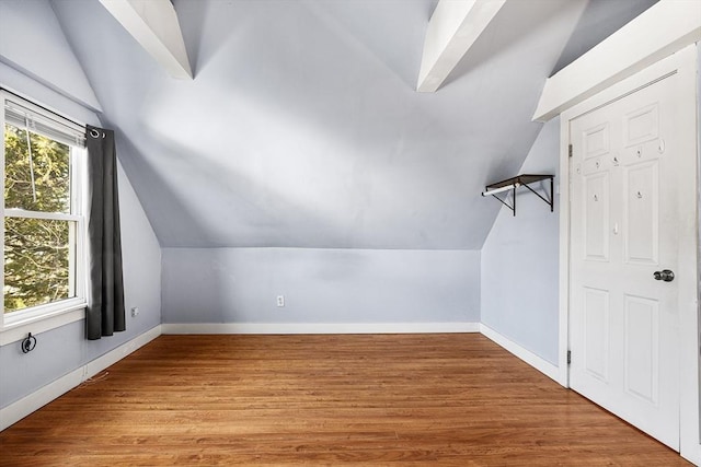 additional living space with lofted ceiling and light hardwood / wood-style flooring