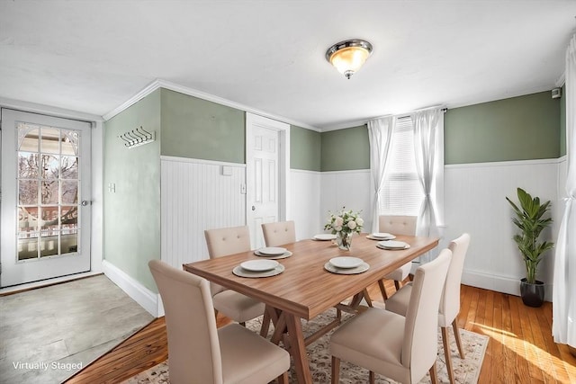 dining area with crown molding and light hardwood / wood-style flooring