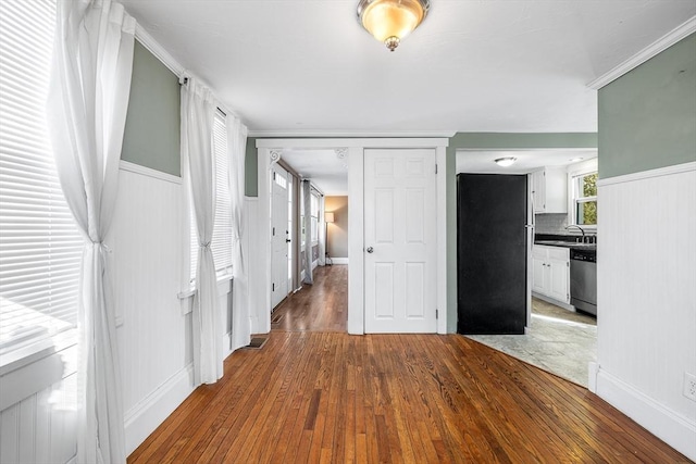 interior space with sink, hardwood / wood-style floors, and crown molding